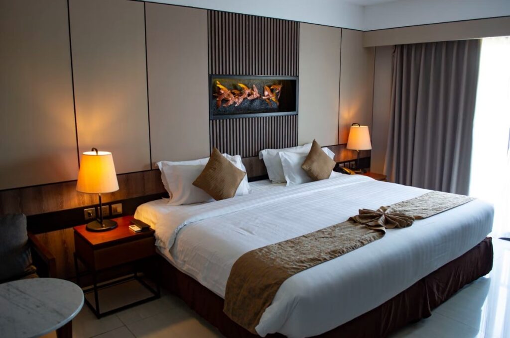 Hotel Room With White Bed And Brown Walls